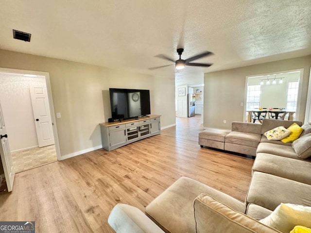 801 W Grossman Dr, Vidalia, GA 30474 - living room with light wood-type flooring, ceiling fan, baseboards, and a textured ceiling