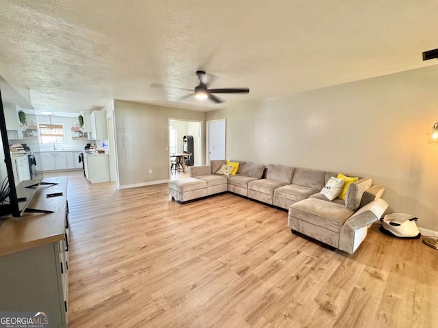 801 W Grossman Dr, Vidalia, GA 30474 - living room with light wood-style floors, ceiling fan, a textured ceiling, and baseboards