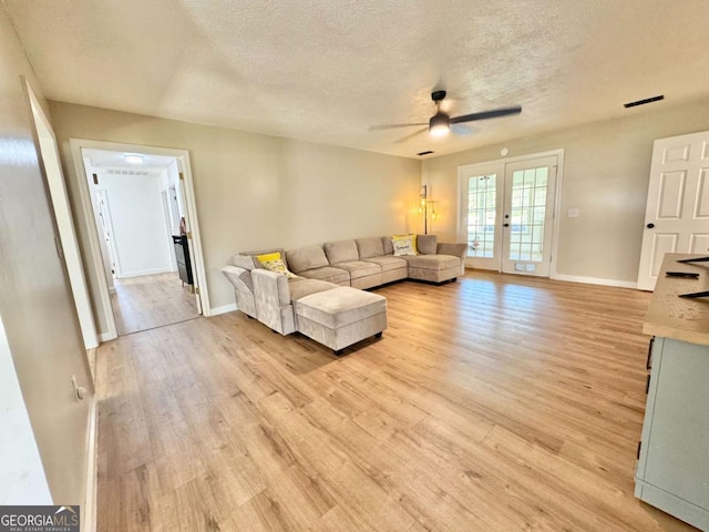 801 W Grossman Dr, Vidalia, GA 30474 - living room featuring a textured ceiling, light wood-style flooring, ceiling fan, french doors, and baseboards