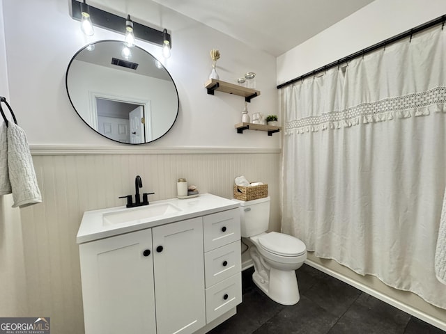 801 W Grossman Dr, Vidalia, GA 30474 - bathroom featuring wainscoting, vanity, tile patterned flooring, toilet, and shower / bath combo with shower curtain