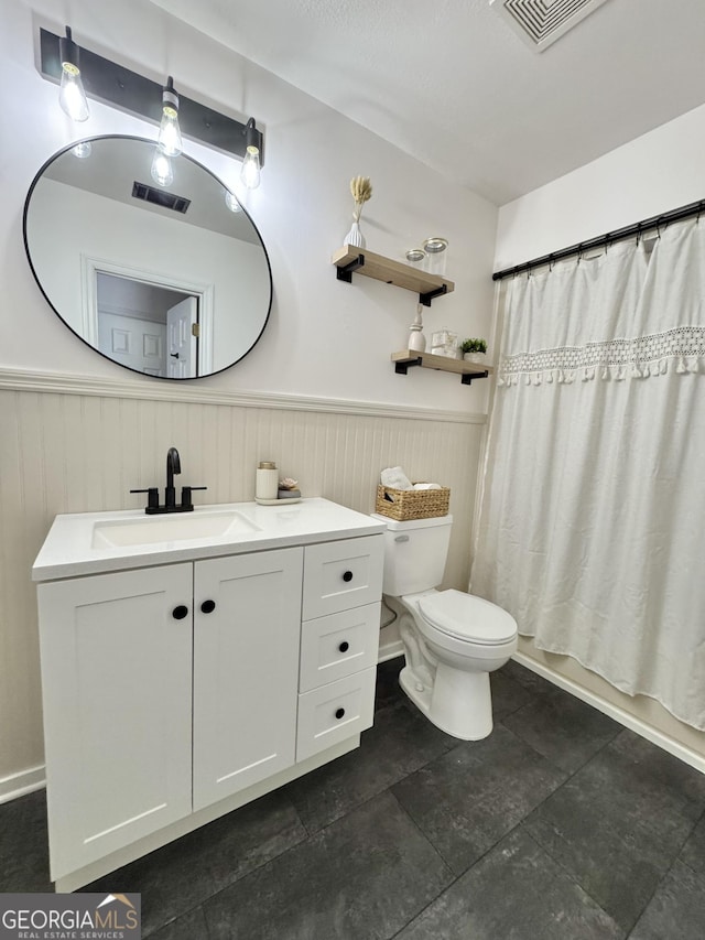 801 W Grossman Dr, Vidalia, GA 30474 - bathroom featuring vanity, a wainscoted wall, and toilet