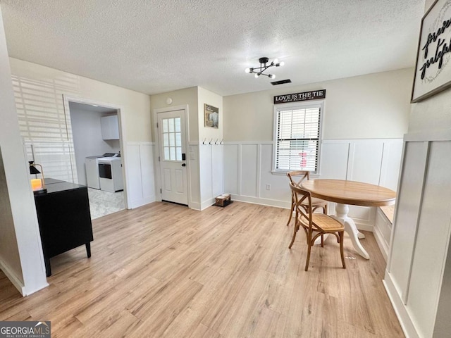 801 W Grossman Dr, Vidalia, GA 30474 - dining area with washer and dryer, a textured ceiling, a decorative wall, healthy amount of natural light, and light wood-style floors