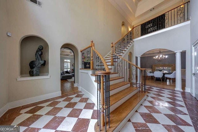 3127 Lenox Rd NE Unit 1, Atlanta, GA 30324 - staircase with visible vents, a chandelier, a towering ceiling, arched walkways, and ornate columns