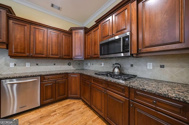 3127 Lenox Rd NE Unit 1, Atlanta, GA 30324 - kitchen with tasteful backsplash, ornamental molding, visible vents, dark stone counters, and appliances with stainless steel finishes