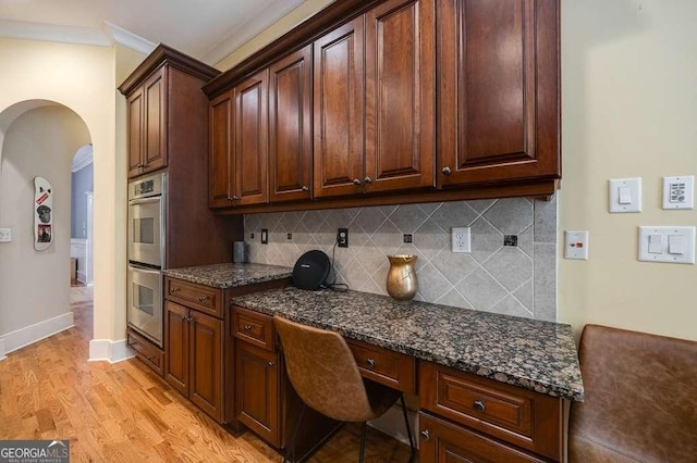 3127 Lenox Rd NE Unit 1, Atlanta, GA 30324 - office area with baseboards, light wood finished floors, built in study area, crown molding, and arched walkways