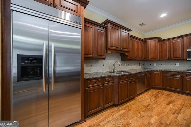 3127 Lenox Rd NE Unit 1, Atlanta, GA 30324 - kitchen featuring a sink, dark stone counters, visible vents, appliances with stainless steel finishes, and ornamental molding