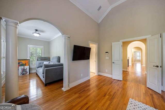 3127 Lenox Rd NE Unit 1, Atlanta, GA 30324 - living area featuring lofted ceiling, decorative columns, ornamental molding, light wood finished floors, and arched walkways