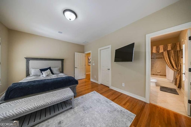 3127 Lenox Rd NE Unit 1, Atlanta, GA 30324 - bedroom with ensuite bath, wood finished floors, and baseboards