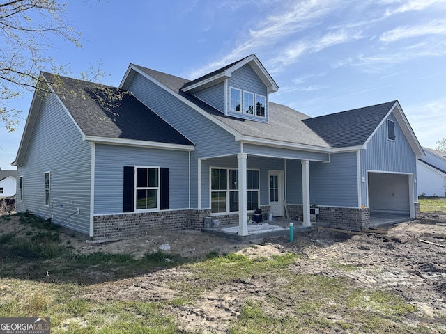 47 Ennis Rd, Pembroke, GA 31321 - view of front facade featuring a shingled roof, brick siding, and a garage