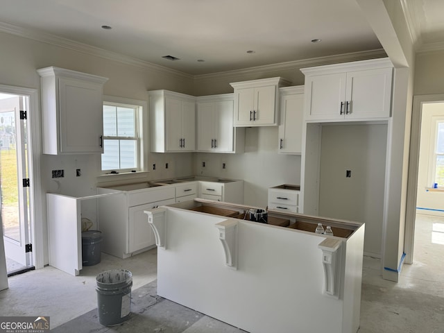 47 Ennis Rd, Pembroke, GA 31321 - kitchen featuring white cabinetry, ornamental molding, and a center island