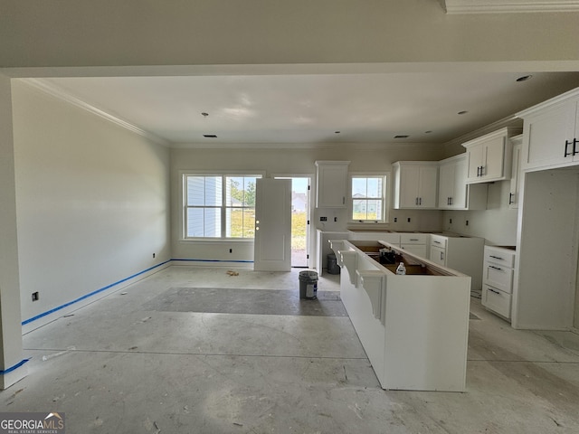 47 Ennis Rd, Pembroke, GA 31321 - kitchen with white cabinets, crown molding, a center island, and baseboards