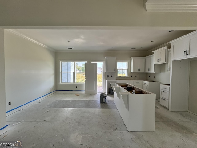 47 Ennis Rd, Pembroke, GA 31321 - kitchen featuring concrete floors, white cabinets, crown molding, baseboards, and a kitchen island