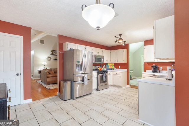 1605 Barrier Rd, Marietta, GA 30066 - kitchen featuring appliances with stainless steel finishes, a sink, light countertops, white cabinets, and hanging light fixtures