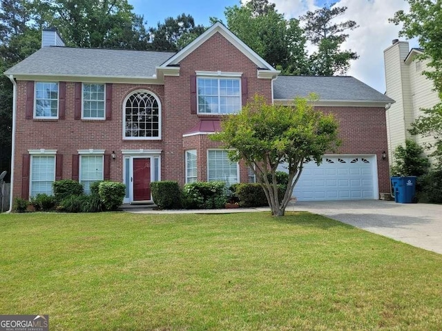 colonial inspired home with concrete driveway, brick siding, a front yard, a garage, and a chimney