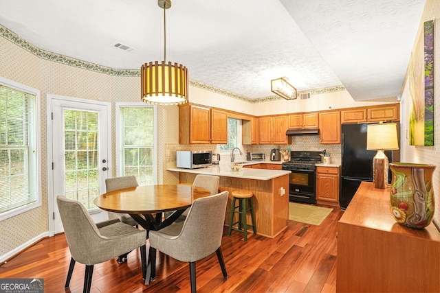 5070 Saddle Bridge Ln, Alpharetta, GA 30022 - dining space featuring wallpapered walls, hardwood / wood-style floors, and a textured ceiling