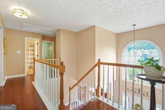 5070 Saddle Bridge Ln, Alpharetta, GA 30022 - corridor with an upstairs landing, hardwood / wood-style flooring, a textured ceiling, baseboards, and attic access