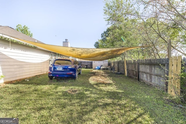 view of yard with fence and a carport
