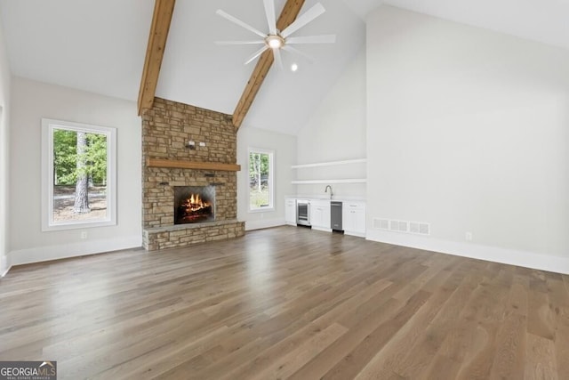 1301 Grayson Pointe Dr, Buckhead, GA 30625 - unfurnished living room featuring high vaulted ceiling, a stone fireplace, a ceiling fan, wood finished floors, and beam ceiling