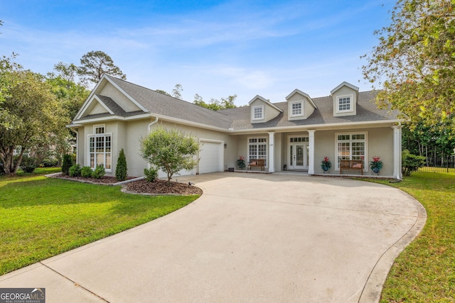 view of front of house featuring stucco siding, an attached garage, a front yard, concrete driveway, and a porch