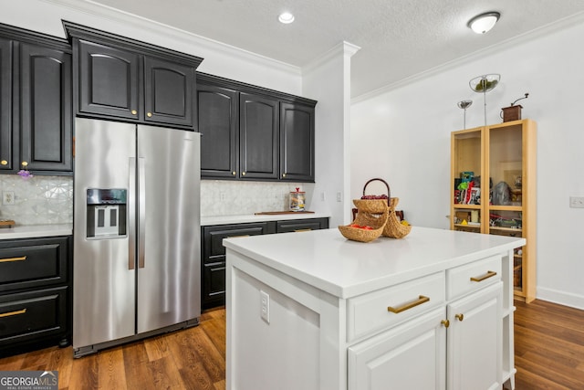 kitchen featuring stainless steel fridge with ice dispenser, ornamental molding, light countertops, backsplash, and recessed lighting