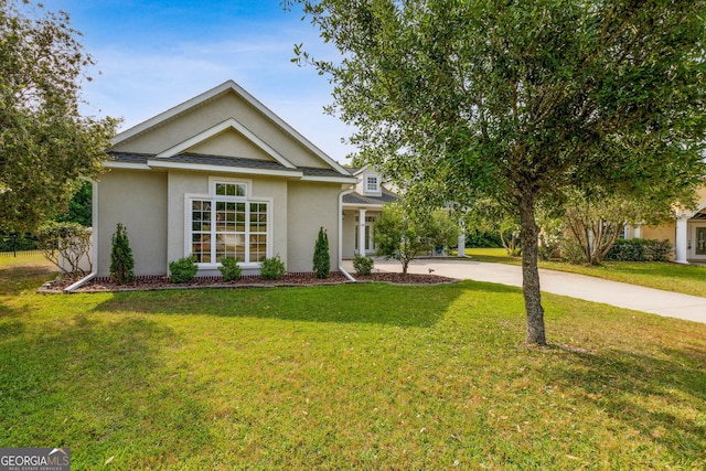 view of front of house with a front lawn, stucco siding, and concrete driveway
