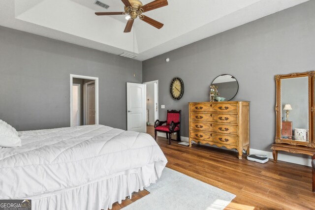 bedroom featuring a towering ceiling, wood finished floors, and ceiling fan