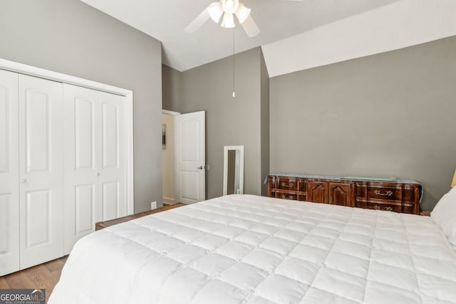 bedroom featuring vaulted ceiling, a closet, wood finished floors, and a ceiling fan