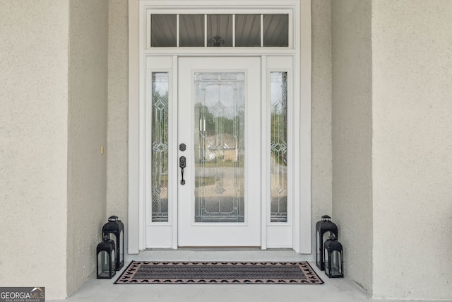 view of exterior entry with stucco siding
