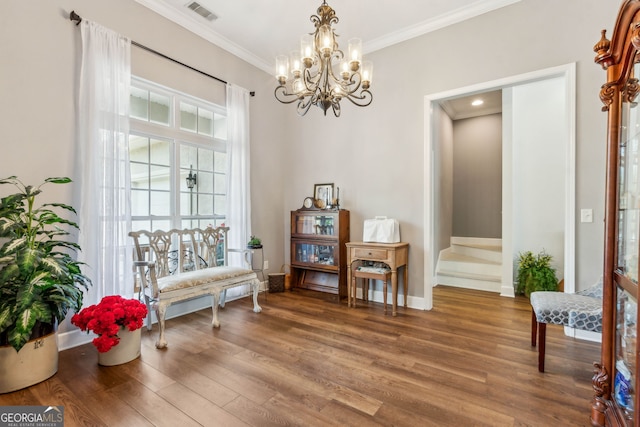 sitting room featuring ornamental molding, wood finished floors, a chandelier, and baseboards