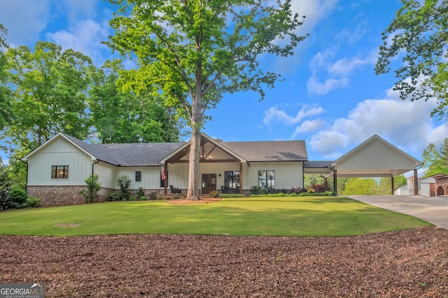 ranch-style home featuring board and batten siding, concrete driveway, a carport, and a front yard