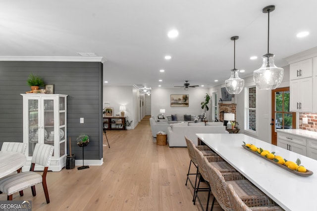 kitchen with white cabinetry, recessed lighting, a ceiling fan, and a kitchen bar