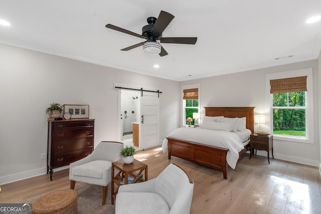 bedroom with baseboards, a barn door, light wood-style flooring, and recessed lighting