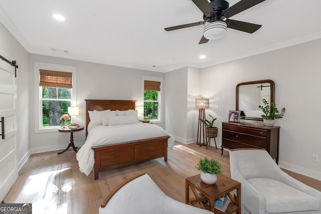 bedroom featuring light wood-style flooring, baseboards, and multiple windows