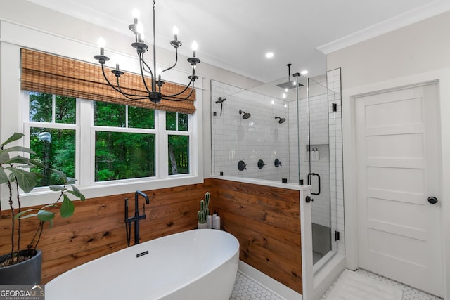 full bath with tile patterned flooring, crown molding, a shower stall, a notable chandelier, and a freestanding tub