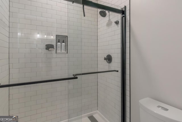 full bathroom featuring toilet and a stall shower