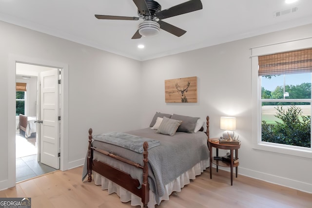 bedroom featuring baseboards, light wood-type flooring, visible vents, and multiple windows