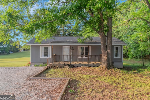 single story home featuring covered porch, a shingled roof, crawl space, and a front yard