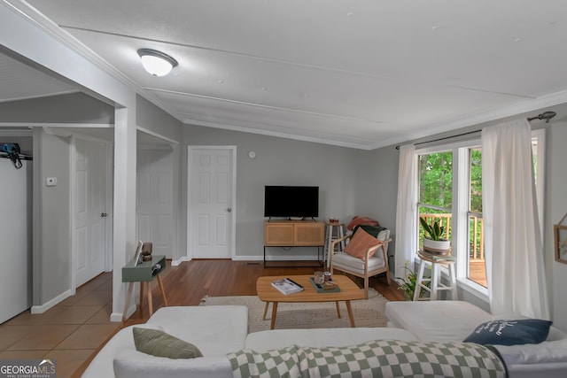 living area with vaulted ceiling, wood finished floors, and ornamental molding