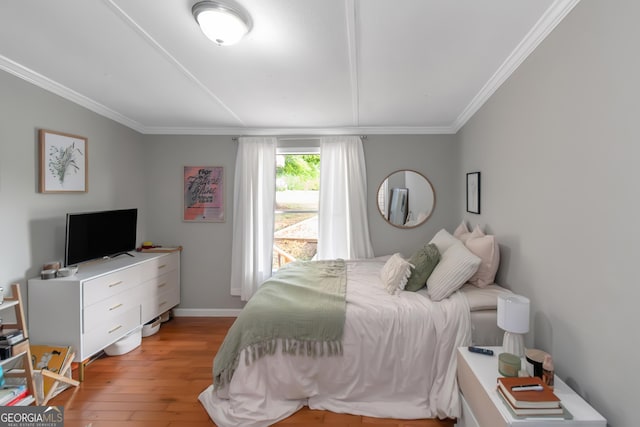 bedroom with baseboards, ornamental molding, and light wood-style floors
