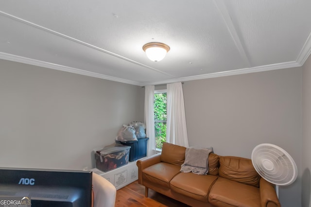 living room with crown molding and wood finished floors