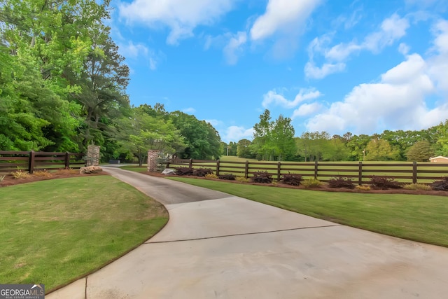 view of community with fence and a lawn