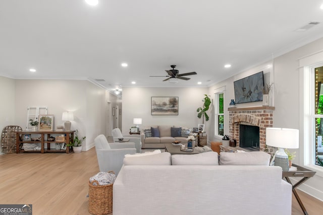 living area featuring baseboards, recessed lighting, light wood-style flooring, and crown molding