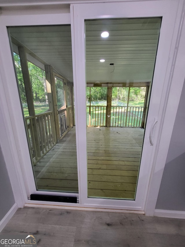 doorway to outside featuring wood finished floors, a wealth of natural light, baseboards, and recessed lighting