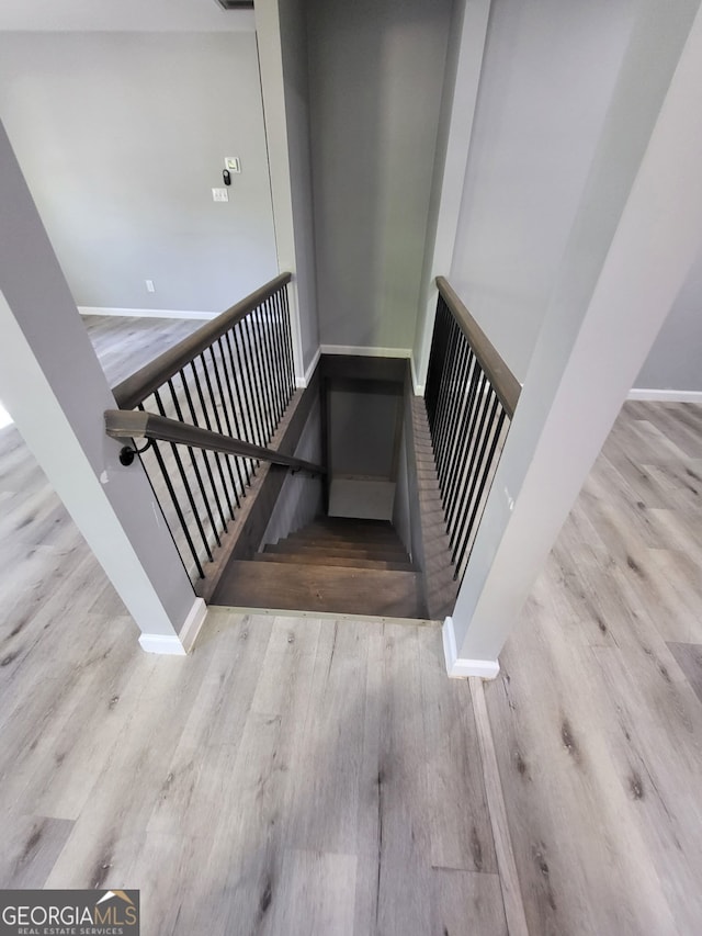 stairs featuring wood finished floors, visible vents, and baseboards