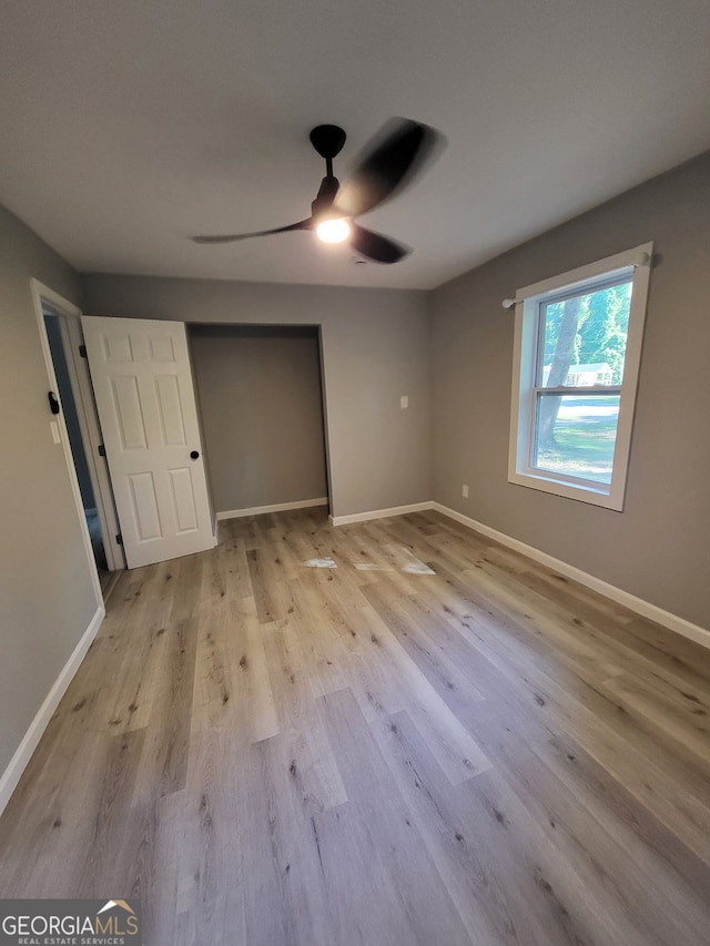 unfurnished bedroom featuring baseboards, a closet, and wood finished floors