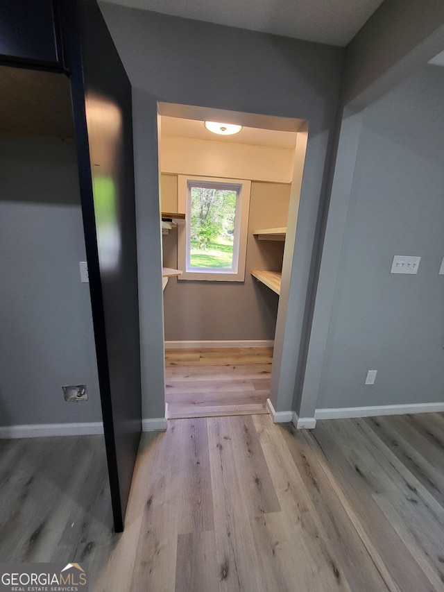 hall featuring baseboards and wood finished floors