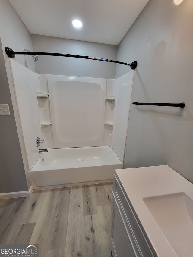 full bath featuring recessed lighting, baseboards, vanity, wood finished floors, and bathing tub / shower combination