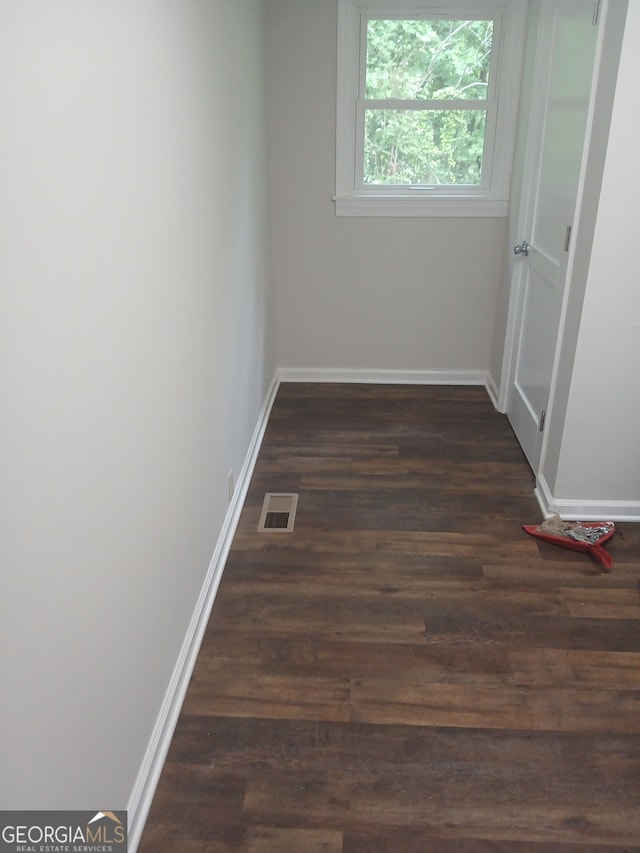 interior space featuring baseboards, visible vents, and wood finished floors