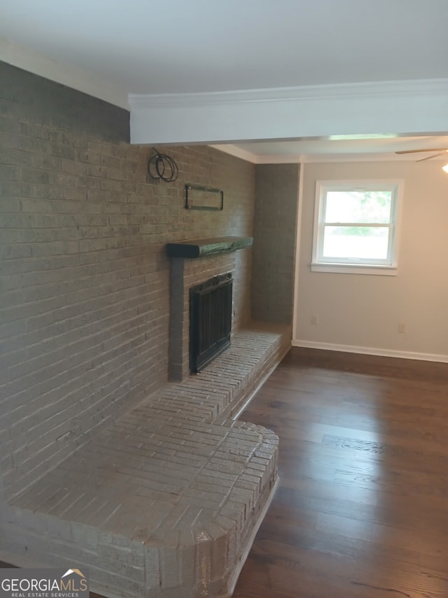 living area featuring ornamental molding, a brick fireplace, baseboards, and dark wood-type flooring