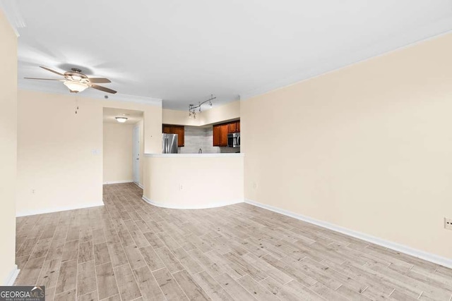 unfurnished living room featuring light wood-style flooring, baseboards, a ceiling fan, and track lighting